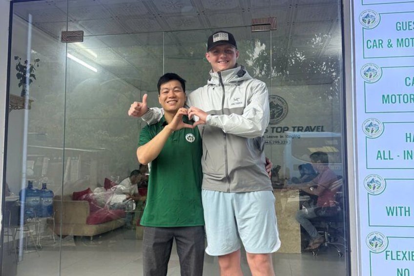Two people in a room with a glass wall, one giving a thumbs up. 3
