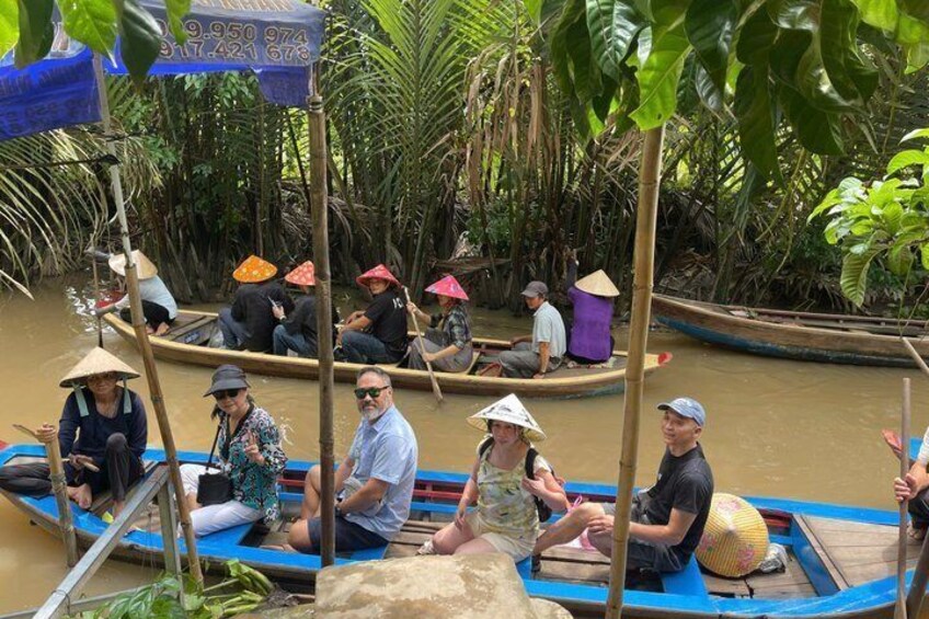 People in canoes on a river surrounded by dense vegetation. 1