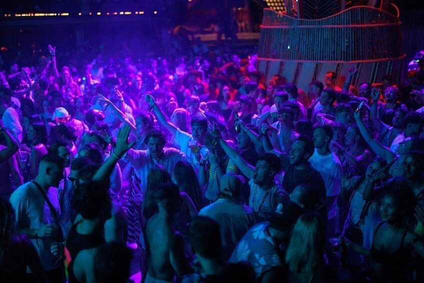 A crowded indoor event with people holding up their hands, possibly taking photos or videos. 5