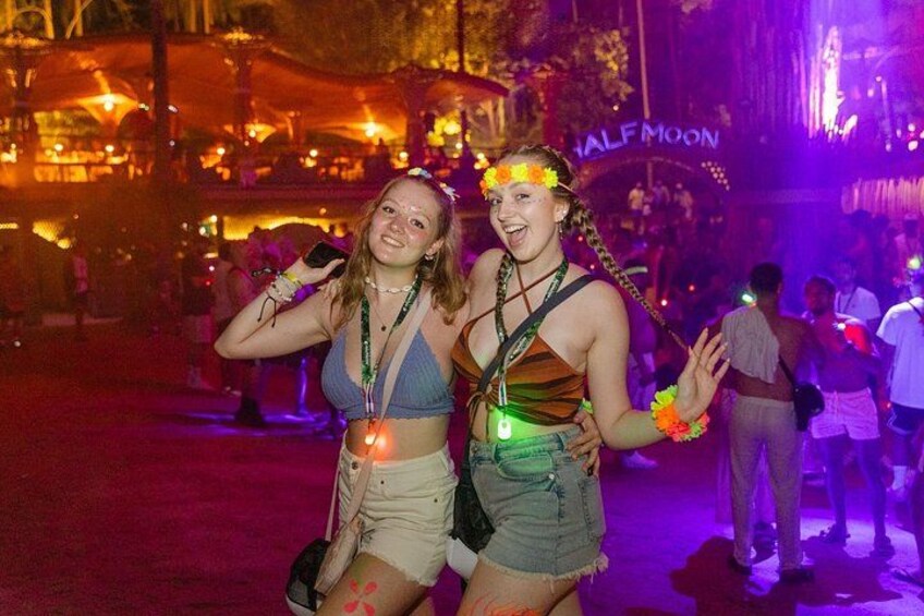 Two people at an outdoor event with a 'HALFMOON' sign in the background. 3