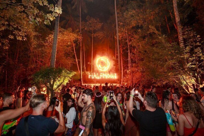A crowd at an outdoor event with a large illuminated sign reading 'HALFWAY.' 3