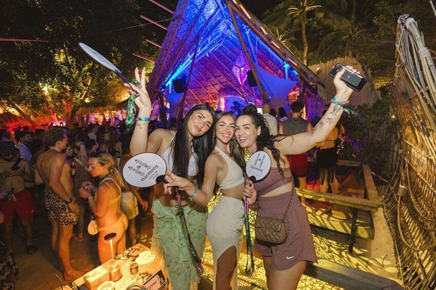 A group of people at an outdoor event with a structure illuminated by blue lights. 2