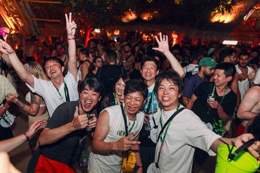 A crowded indoor event with people dancing and raising their hands. 4