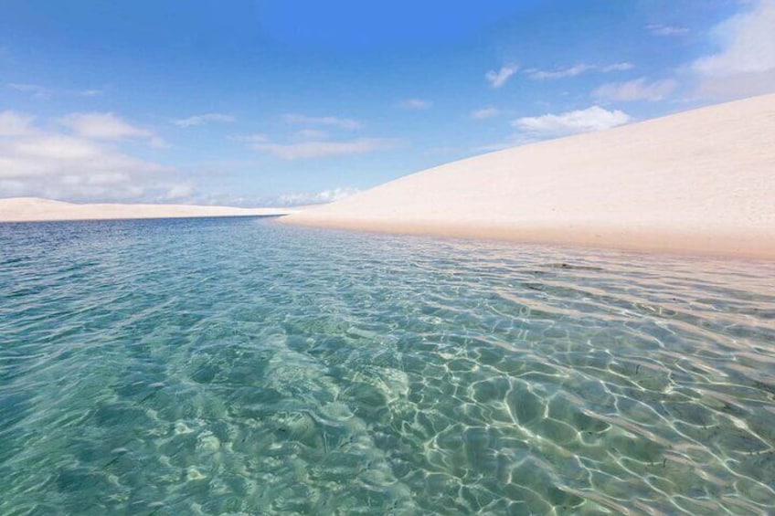 A clear turquoise sea with a sandy beach. 5