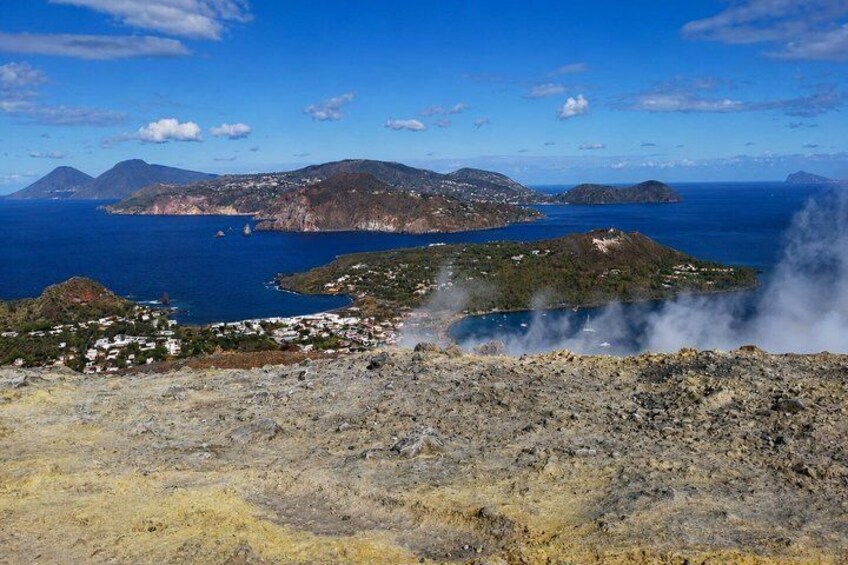 A coastal landscape with a village, mountains, and a body of water. 1