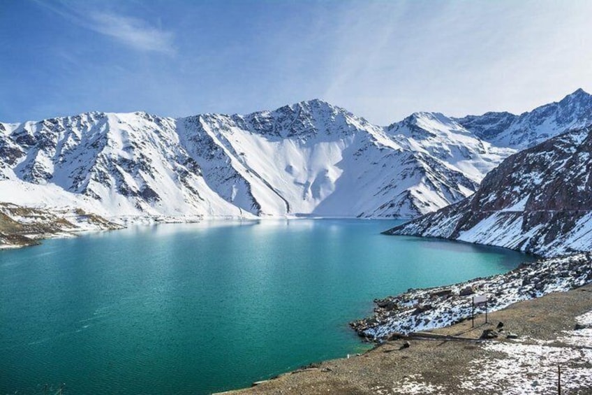 A turquoise lake surrounded by snow-covered mountains. 2