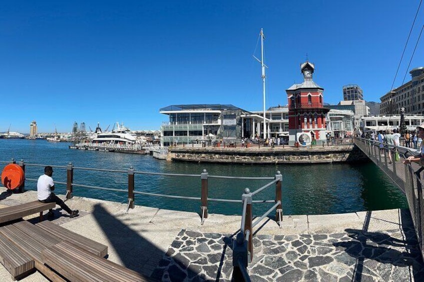 A waterfront with a red lighthouse, a dock, and a boat. 5