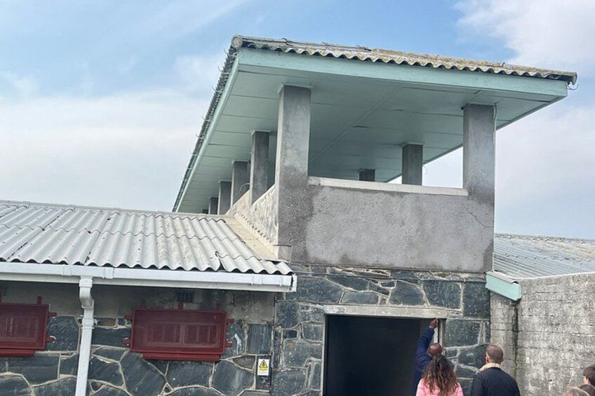 A stone building with a tiled roof and a covered upper section. 3