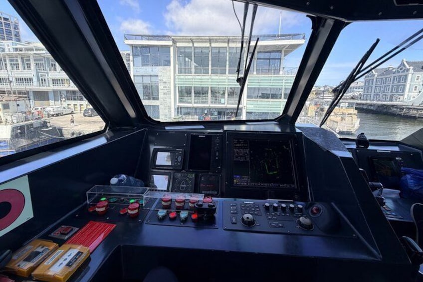 A ship's control room with multiple screens and control panels. 2