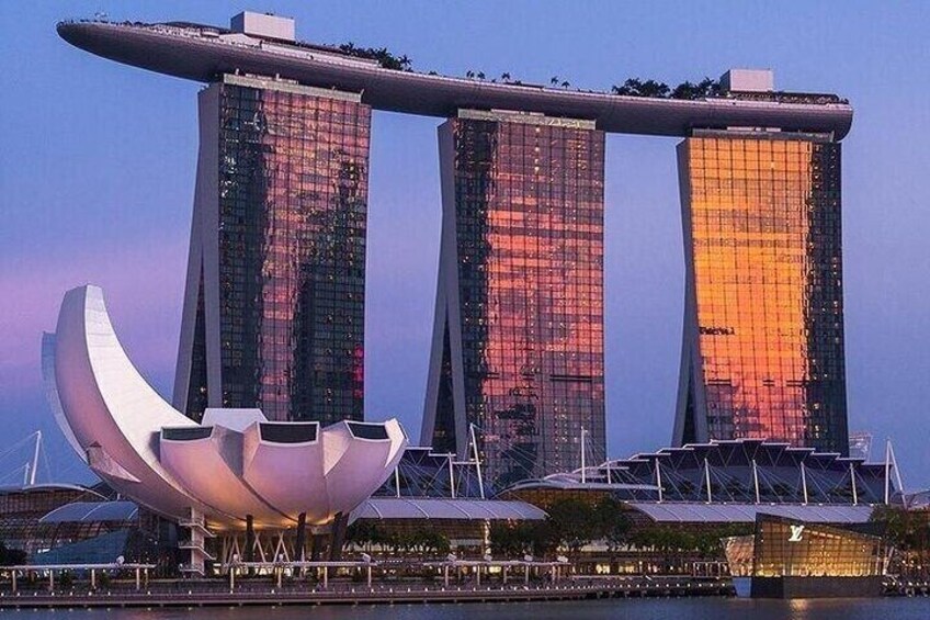 The Marina Bay Sands hotel with its distinctive three towers and a curved, boat-shaped structure in front. 3