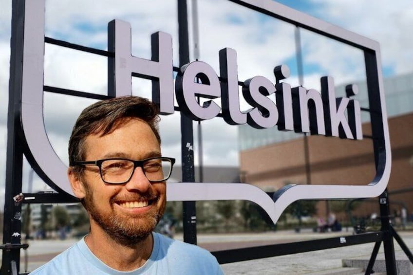 A person standing in front of a sign that reads 'Helsinki.' 2