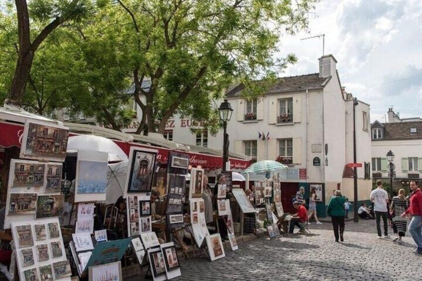 A street market with art stalls and pedestrians. 3