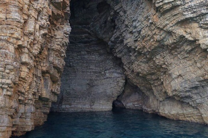 A coastal rock formation with a narrow passage leading into a body of water. 4