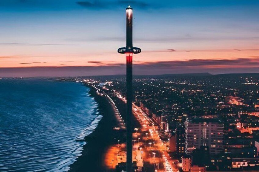 A cityscape at dusk with a prominent tall tower and a beach. 1