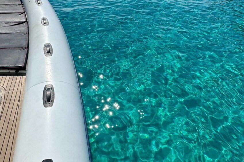 A clear blue pool with a wooden deck and a white inflatable structure. 2