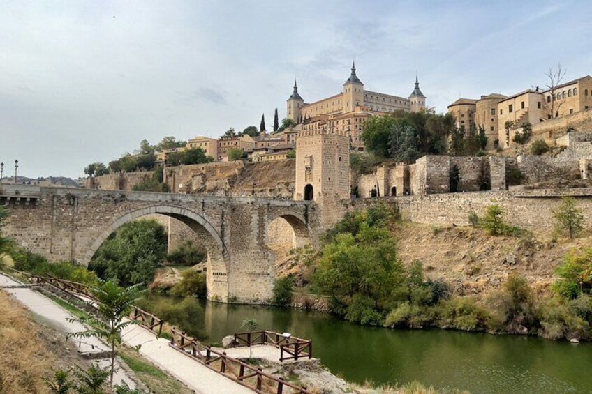 A historic bridge, a river, and a castle-like building with towers. 1