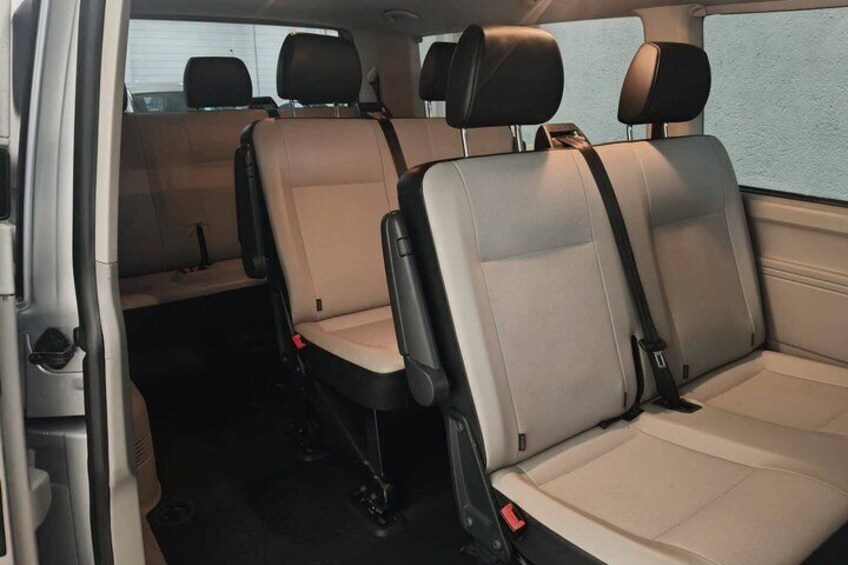 A vehicle interior with beige seats and black headrests. 2