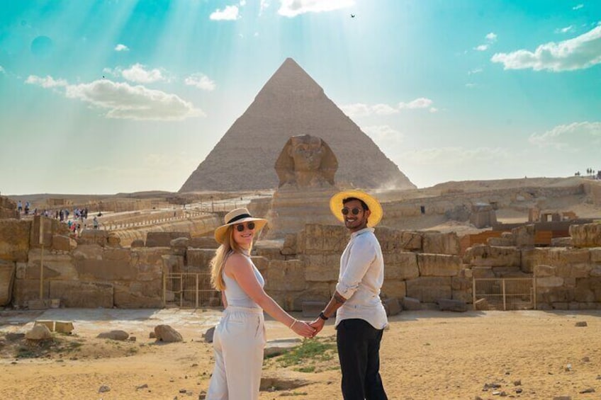 A couple holding hands in front of the Great Pyramid of Giza. 5