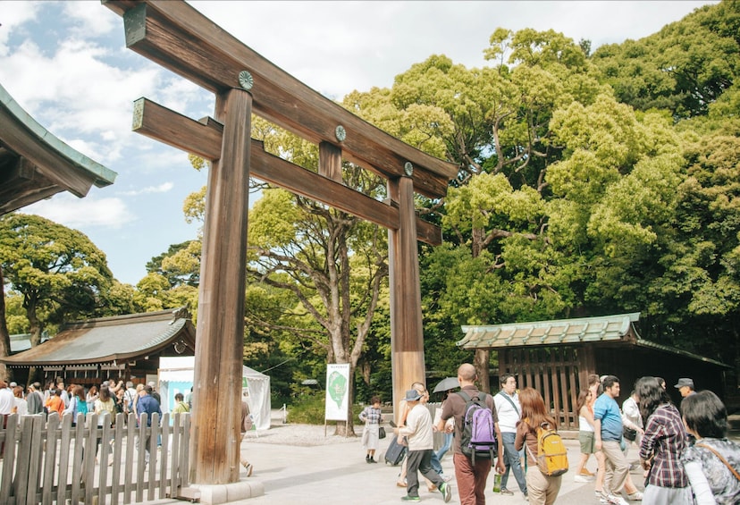 Perinteinen japanilainen torii-portti, jonka ympärillä kävelee vierailijoita. 2