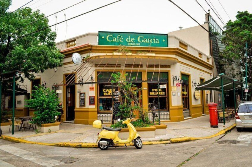 A café named Café de García with outdoor seating and a yellow scooter parked in front. 2