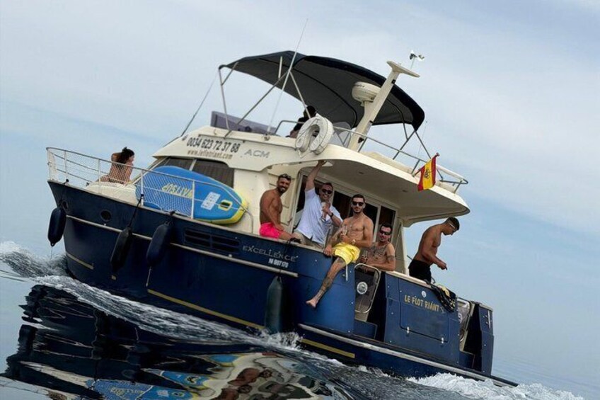 A boat with people on board, a lifebuoy, and a flag. 3