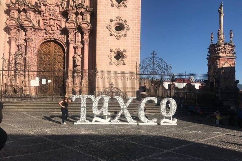 A historic building with ornate architecture, a large central tower, and a statue. 5