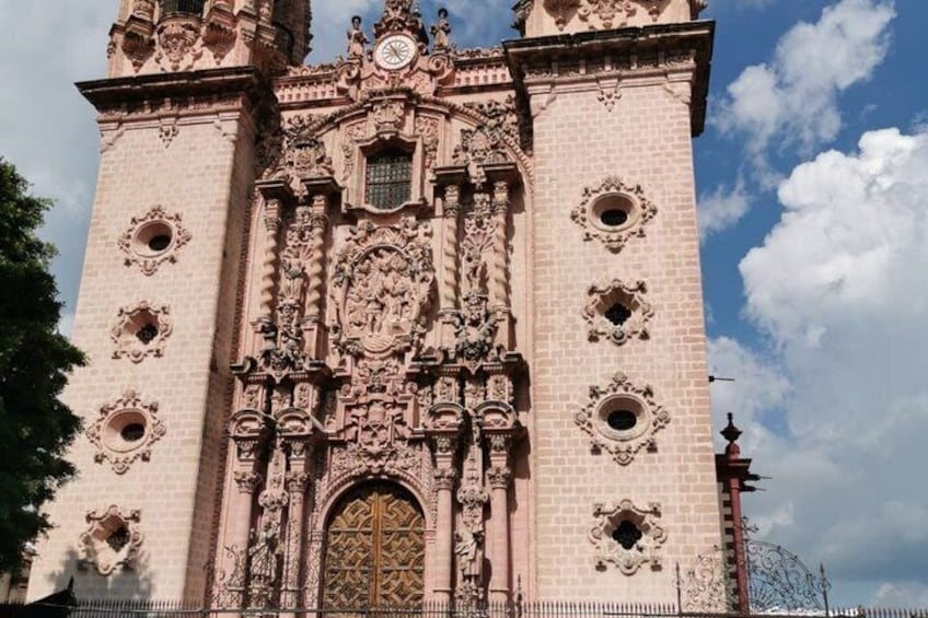 A historic building with ornate architecture, featuring a large central door and decorative elements. 2