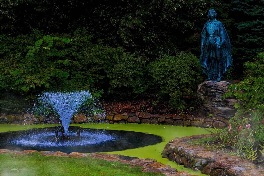 A statue, a fountain, and a pond in a garden. 3