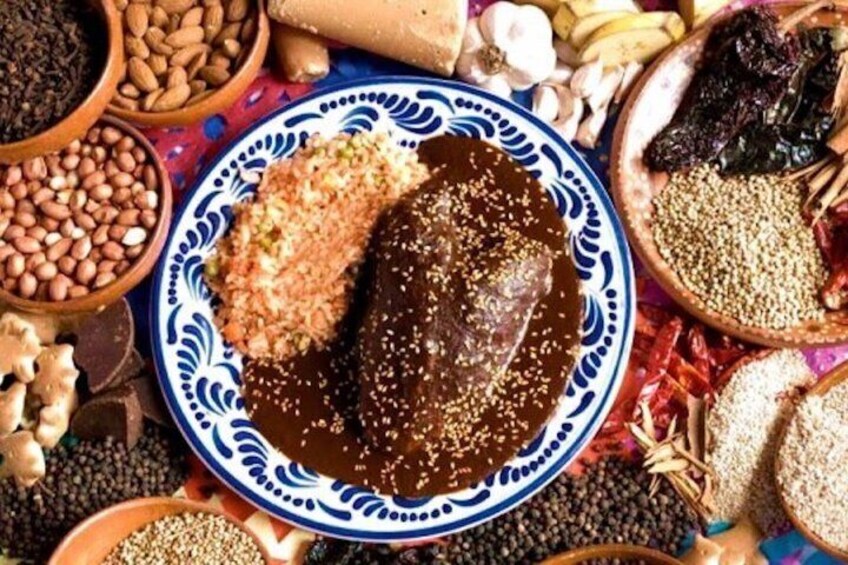 A plate of mole with a side of rice, surrounded by various spices and ingredients. 3