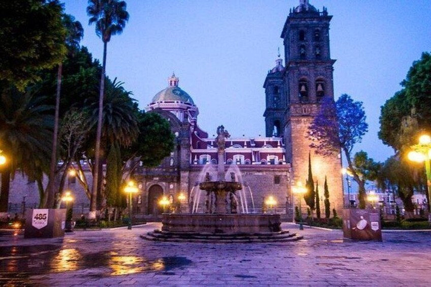 A historic building with a dome and bell tower, surrounded by palm trees and a fountain. 2