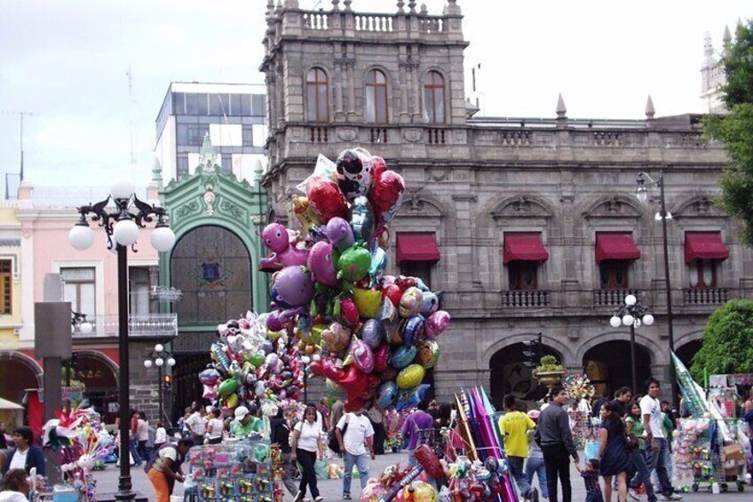 A colorful balloon sculpture in front of a historic building. 4