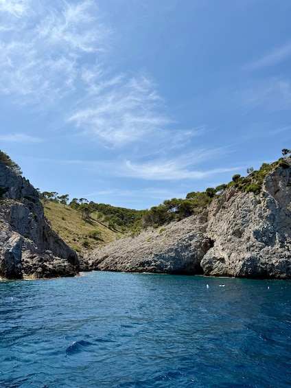 A coastal landscape with rocky cliffs and clear blue water. 2