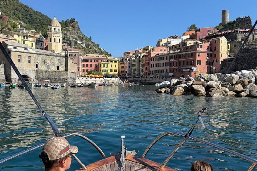 A boat on a calm river with colorful buildings on the opposite bank. 3