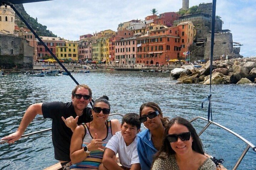A group of people on a boat with a colorful waterfront town in the background. 3
