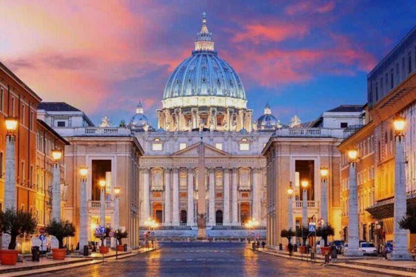 A grand building with a large dome, surrounded by classical architecture and a wet street reflecting lights. 1