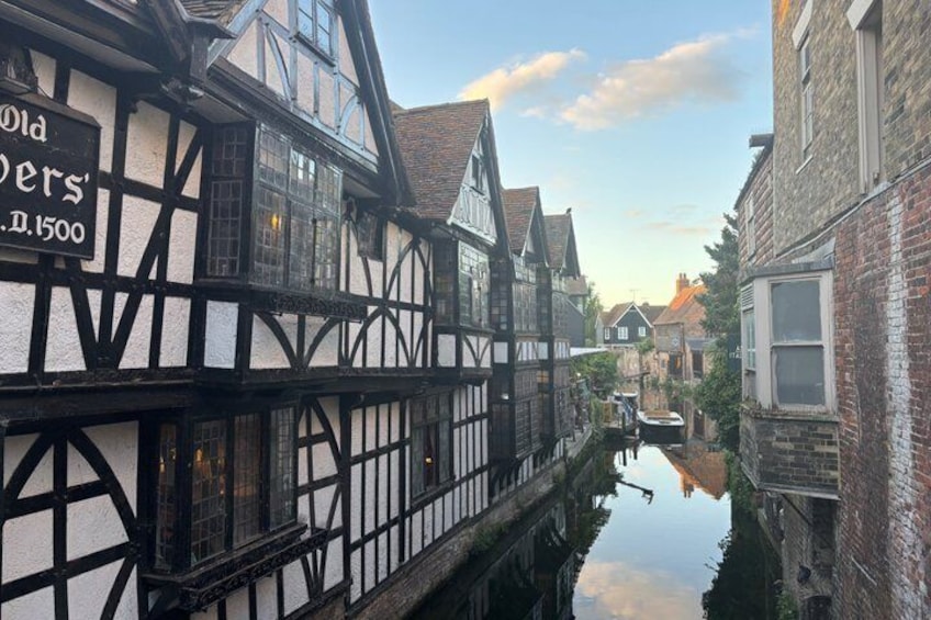 A narrow waterway flanked by traditional half-timbered buildings, one with a sign reading 'Old Brewers.' 1