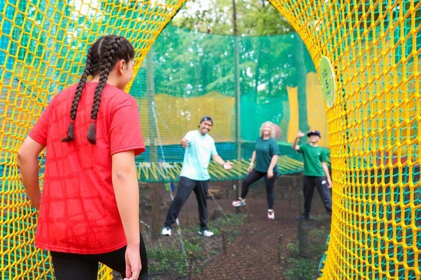 A netted obstacle course with participants. 4