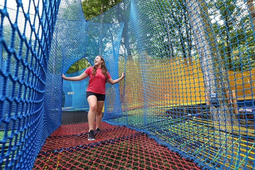 A person on a trampoline inside a netted enclosure. 5