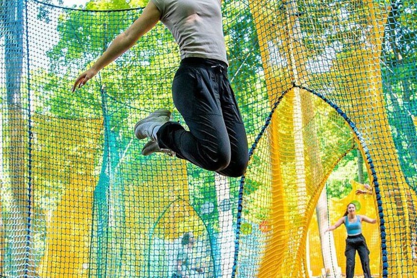 A person jumping through a netted obstacle course in an outdoor setting. 2
