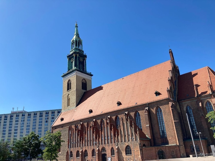 Suuri tiilikirkko, jossa on korkea torni ja kello. 5