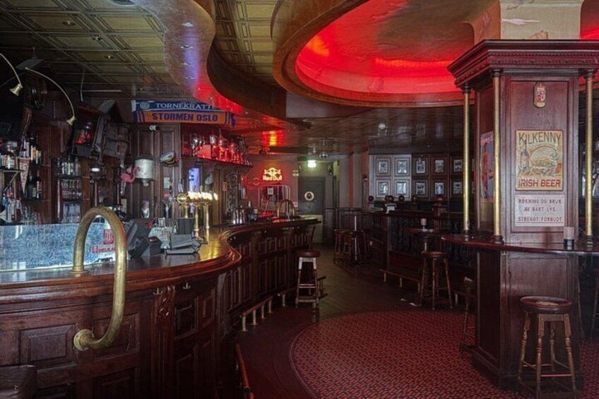 A bar with wooden decor, a red carpet, and a sign for 'STORMEN OSLO.' 5