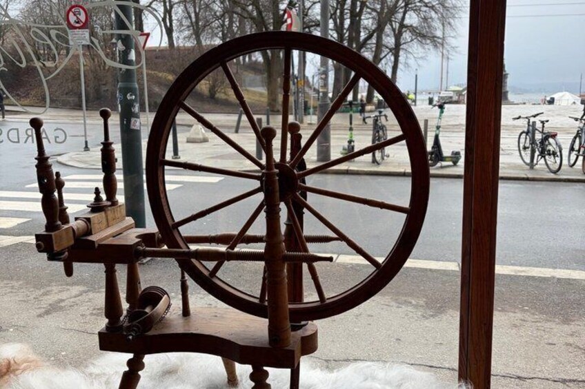 A wooden spinning wheel with a large wheel and a wooden frame. 4
