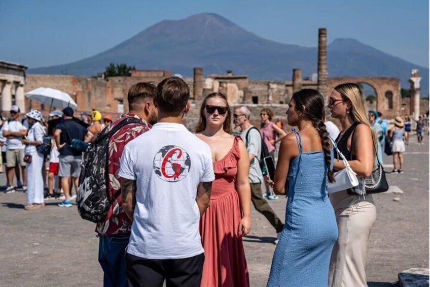 Tourists at an ancient ruin with a mountain in the background. 1