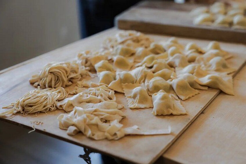 A wooden table with dumplings and noodles. 3