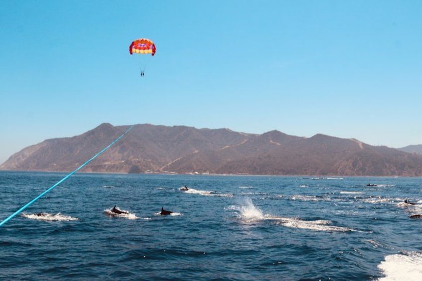 A parasail over water with mountains in the background. 3