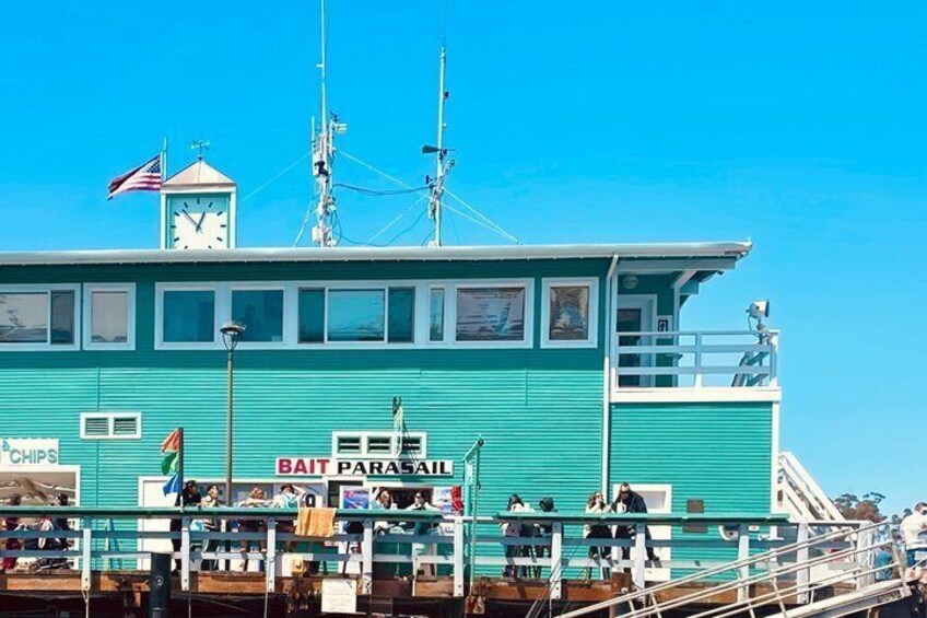 A turquoise boat with a clock tower, a lifebuoy, and a sign that reads 'Bait Parasol.' 3
