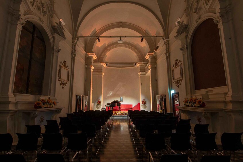 An interior of a church with rows of pews, an altar, and ornate columns. 4