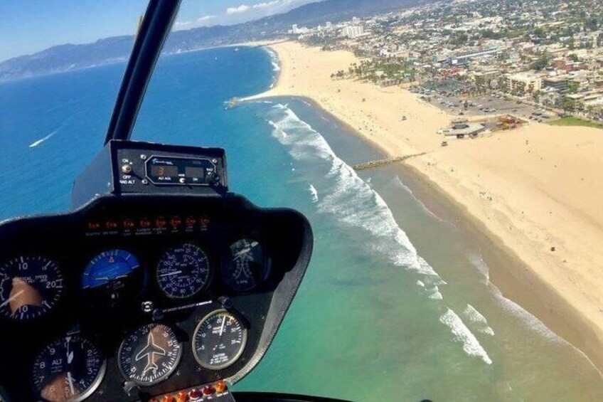 A helicopter cockpit with a view of a beach and ocean. 2
