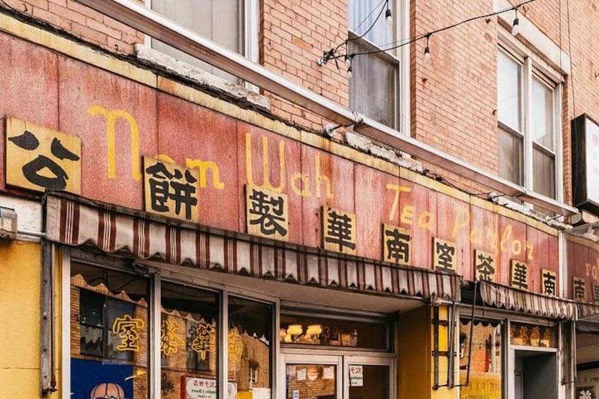 A storefront with a sign in a foreign language, a brick building, and a window display. 2