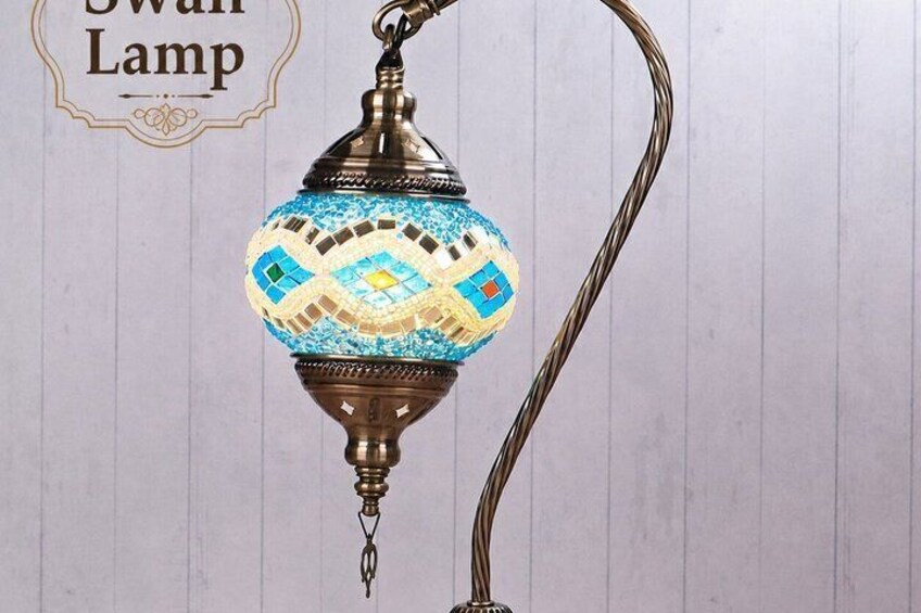 A swan lamp with a decorative blue and white mosaic pattern, a metal base, and a curved metal stand. 3